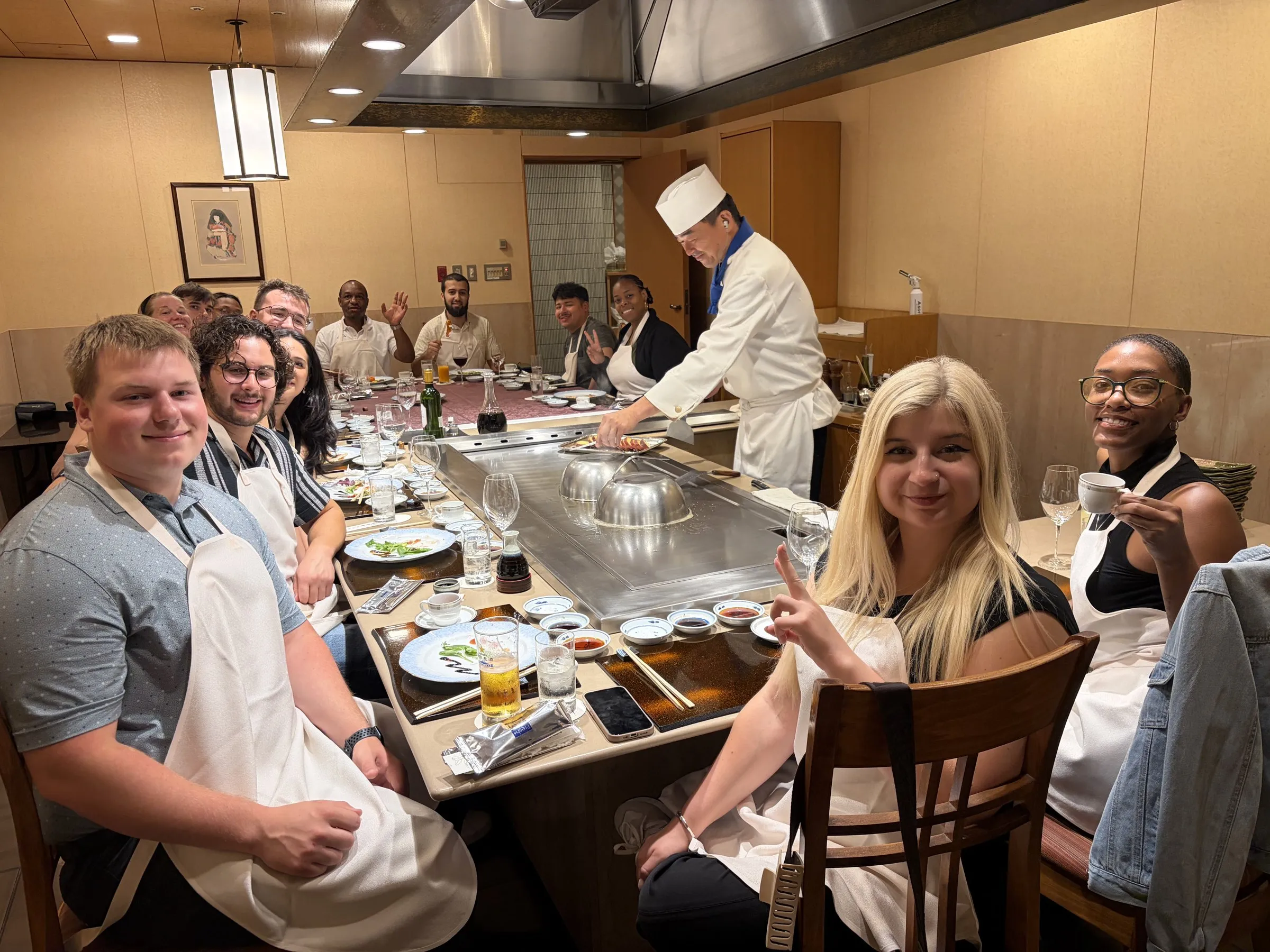 Classmates sharing a meal around a teppanyaki counter in Hamamatsu.
